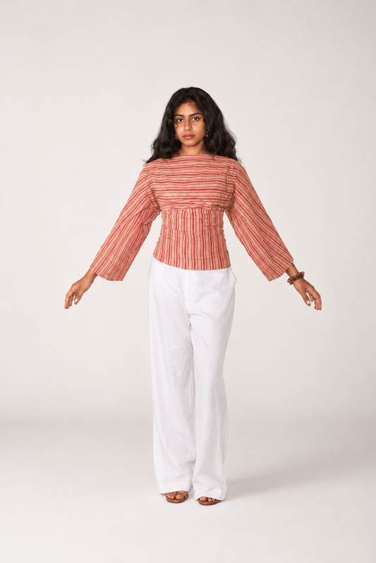 Woman wearing a striped top and white pants on a white background