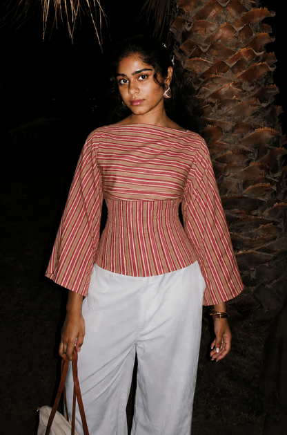 Woman wearing the Rosé pink and rust striped tie-back top with long bell sleeves