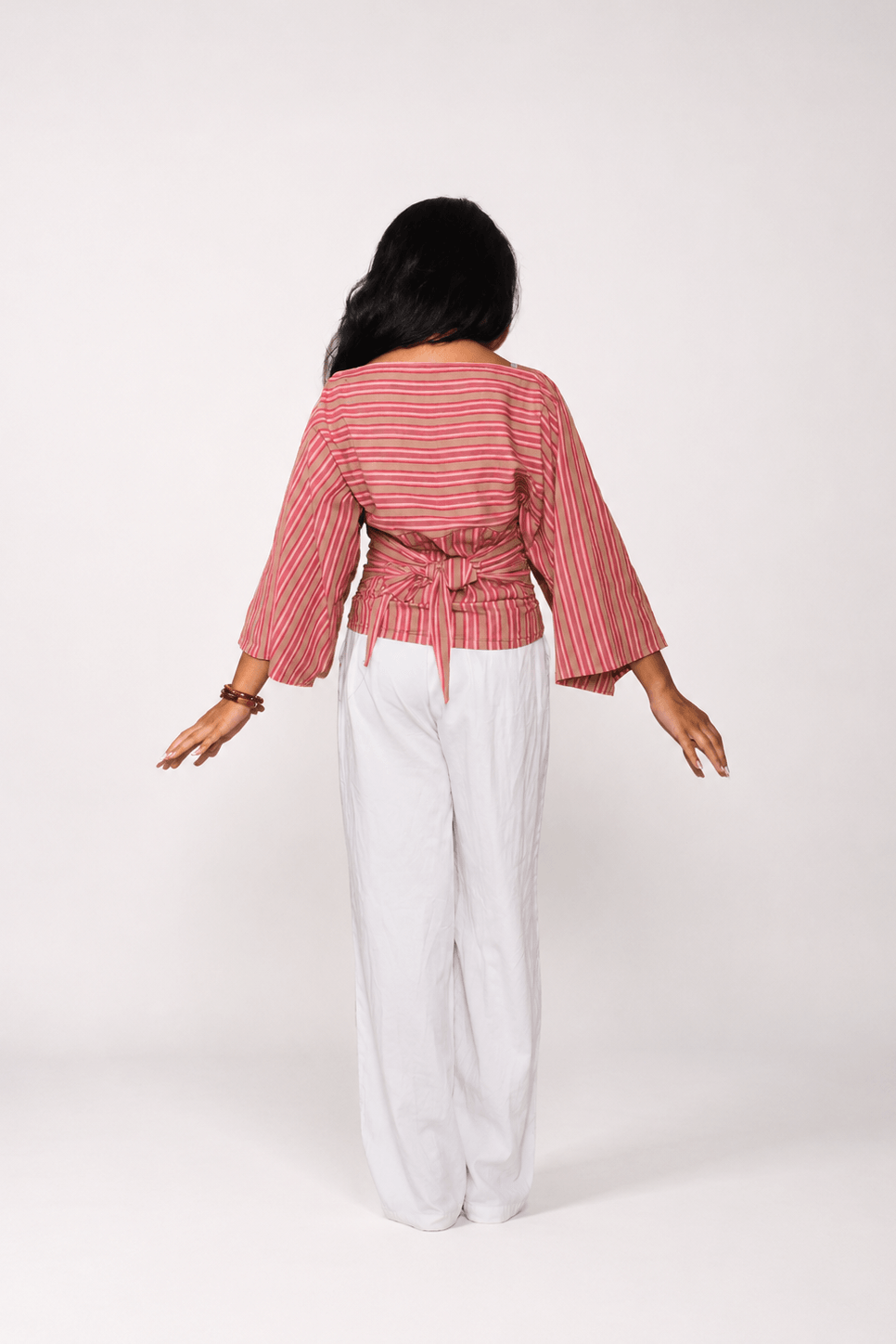 Person wearing a striped and white pants on a white background