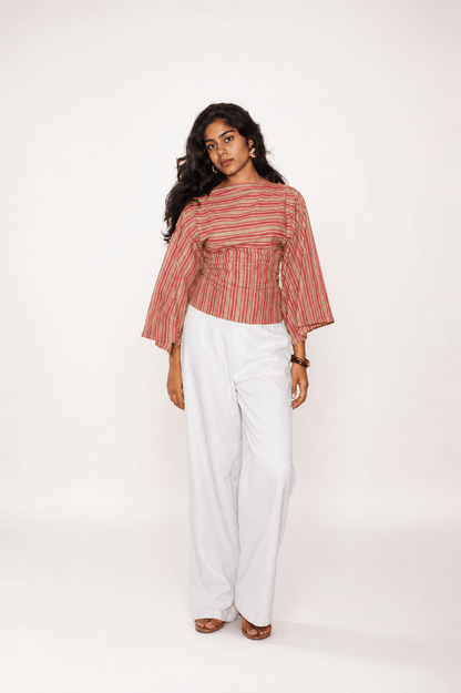 Woman wearing a striped top with white pants on a white background