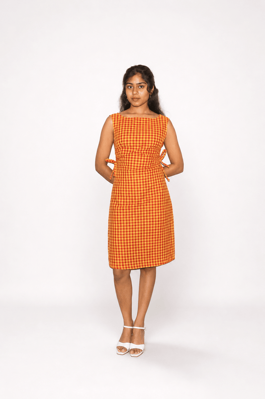 Woman wearing an orange checkered dress on a white background
