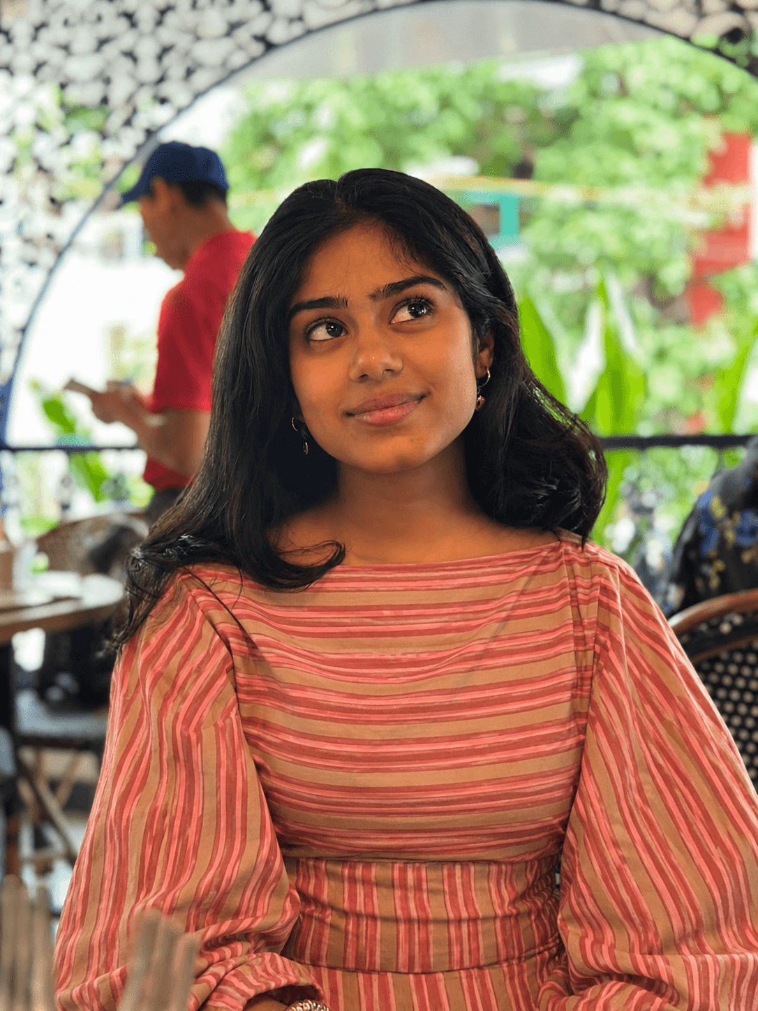 Woman in the Rose Stripe Tie-Back Top with bell sleeves outside a cafe