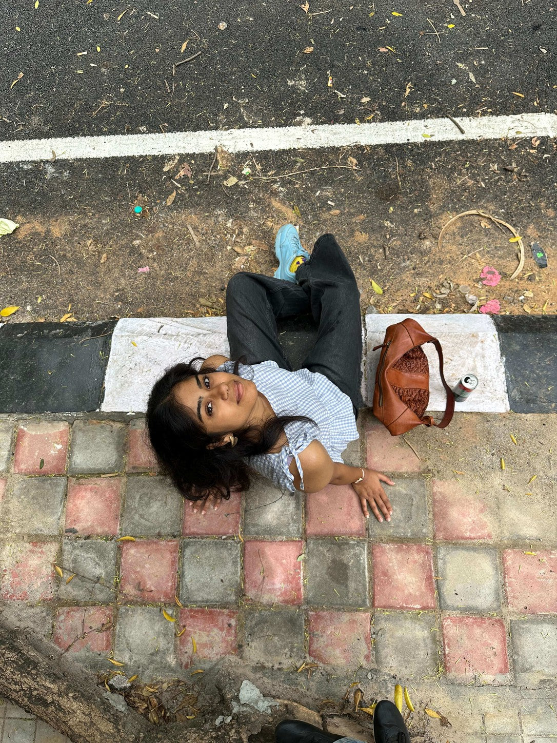 Woman lying on a patterned pavement wearing a mazo handloom top