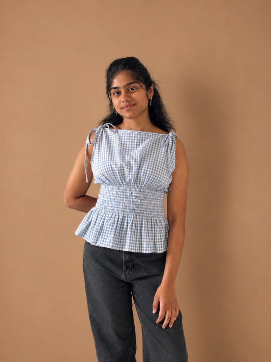 mazo Bluebell Breeze cotton peplum top for women in blue and white gingham, worn with charcoal jeans, front view