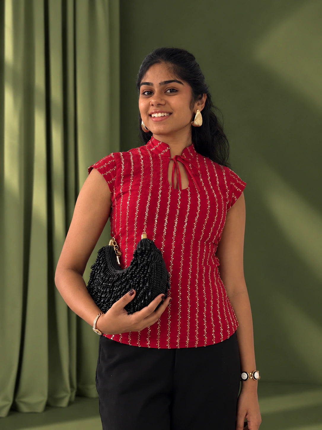 mazo Mirchi red top styled with black trousers and a beaded bag