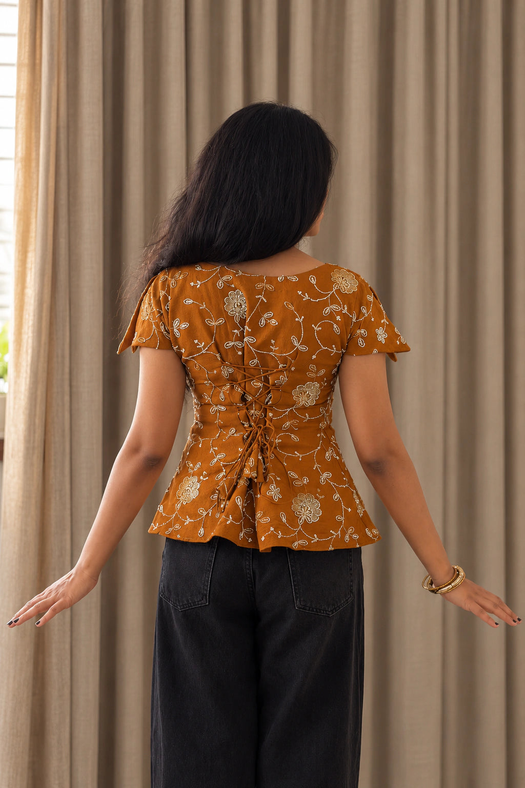 mazo Pataka top, back view of the lace up back and the peplum flare