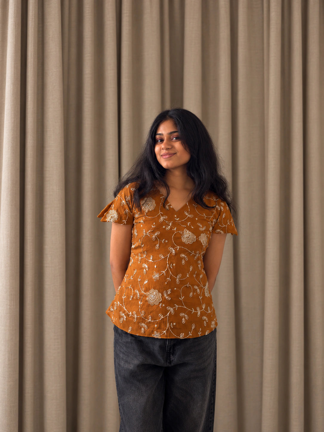 mazo Pataka rust top styled with black wide leg jeans and sandals