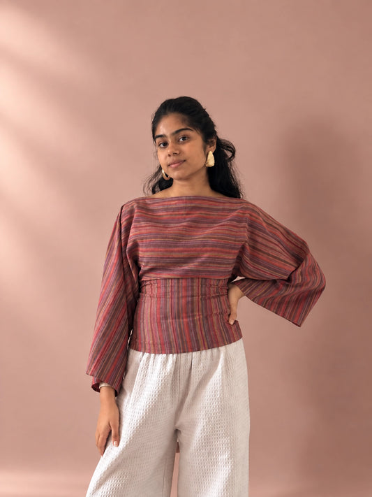 mazo Rosé bell sleeve top for women in pink and rust stripes, worn with white trousers, front view