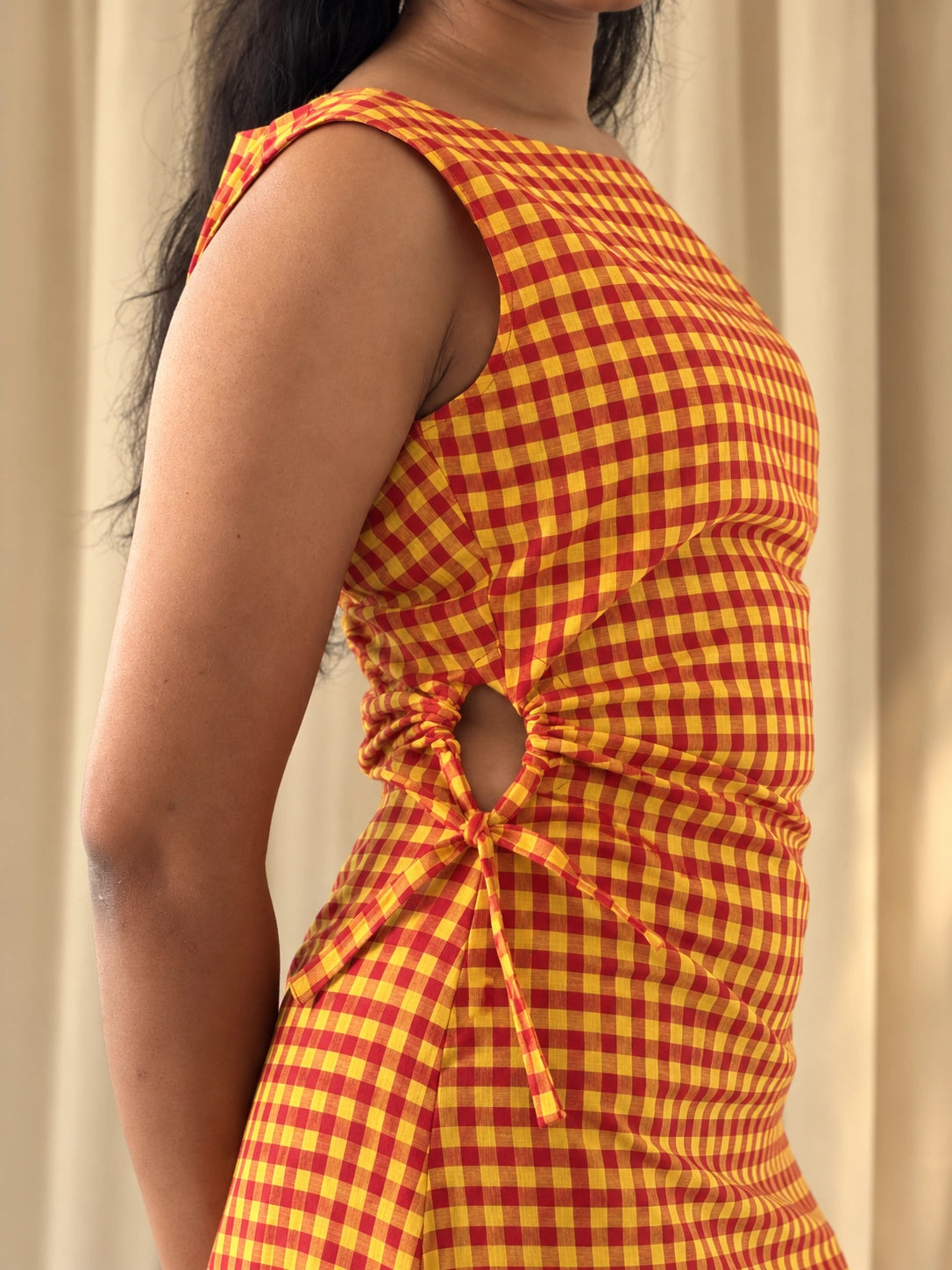mazo Close view of the Summer Jam Midi Dress's side cut-out tie and orange gingham check